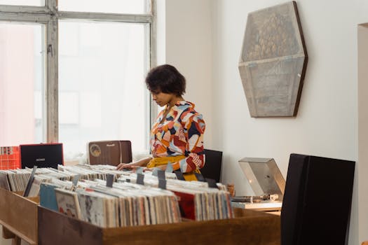 A woman in a colorful shirt looks through vinyl records at a vintage music store.