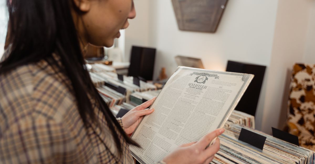 person smiling while browsing vinyl records in a cozy record store