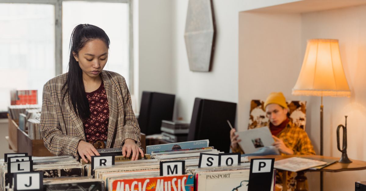 Gen Z teenager browsing vinyl records in a record store