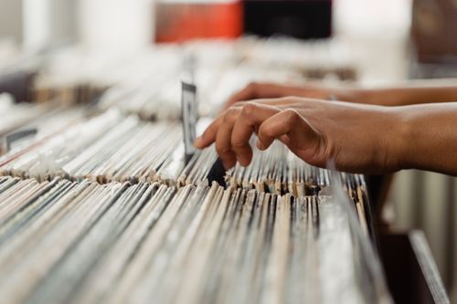Free Close-up of hands searching through vinyl records, depicting a personal music shopping experience. Stock Photo