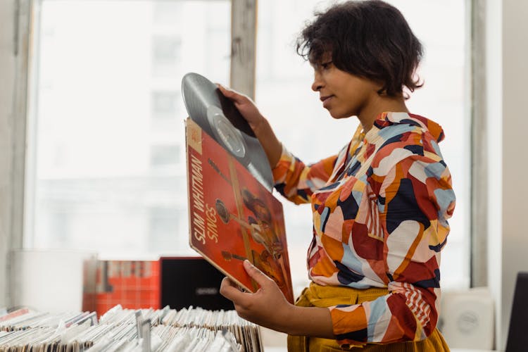 Woman In Colorful Shirt Holding Vinyl Record In Red Cover