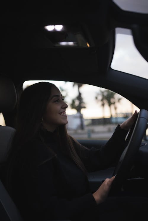 Smiling Woman in Black Long Sleeve Shirt Driving A Car