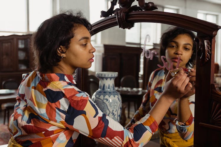 A Woman Writing On A Mirror