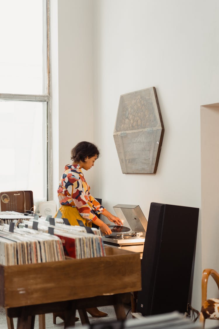 A Woman Using A Turntable Audio Equipment