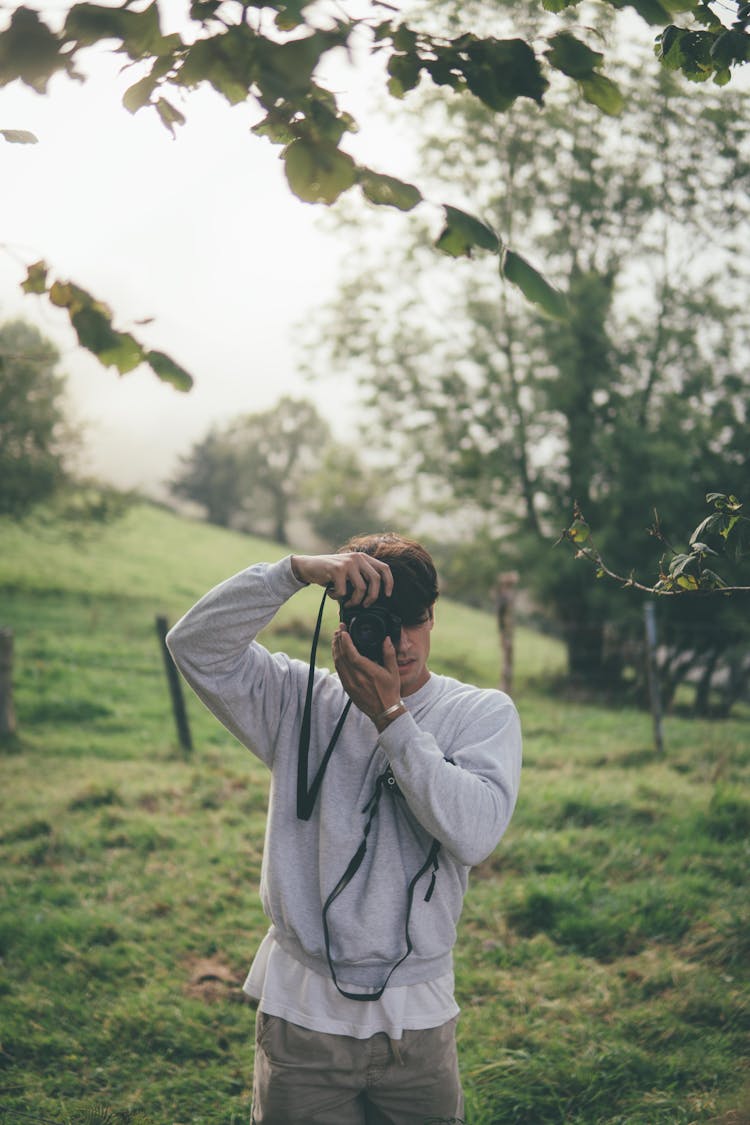 Man In Gray Sweatshirt Taking Photo