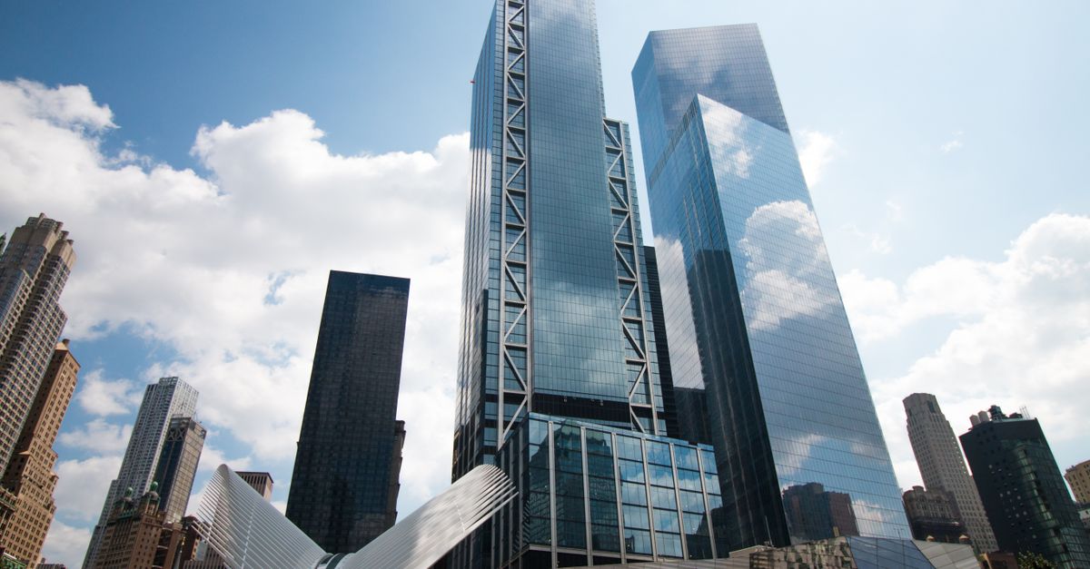 Low angle view of modern skyscrapers in Manhattan, reflecting clouds in New York City.