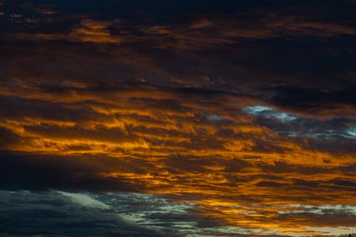 Free A vibrant and dramatic sky during sunset with dark stormy clouds. Stock Photo