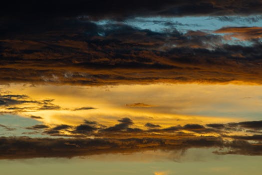 Stunning photo of dark and vibrant clouds during a dramatic sunset, showcasing nature's beauty.
