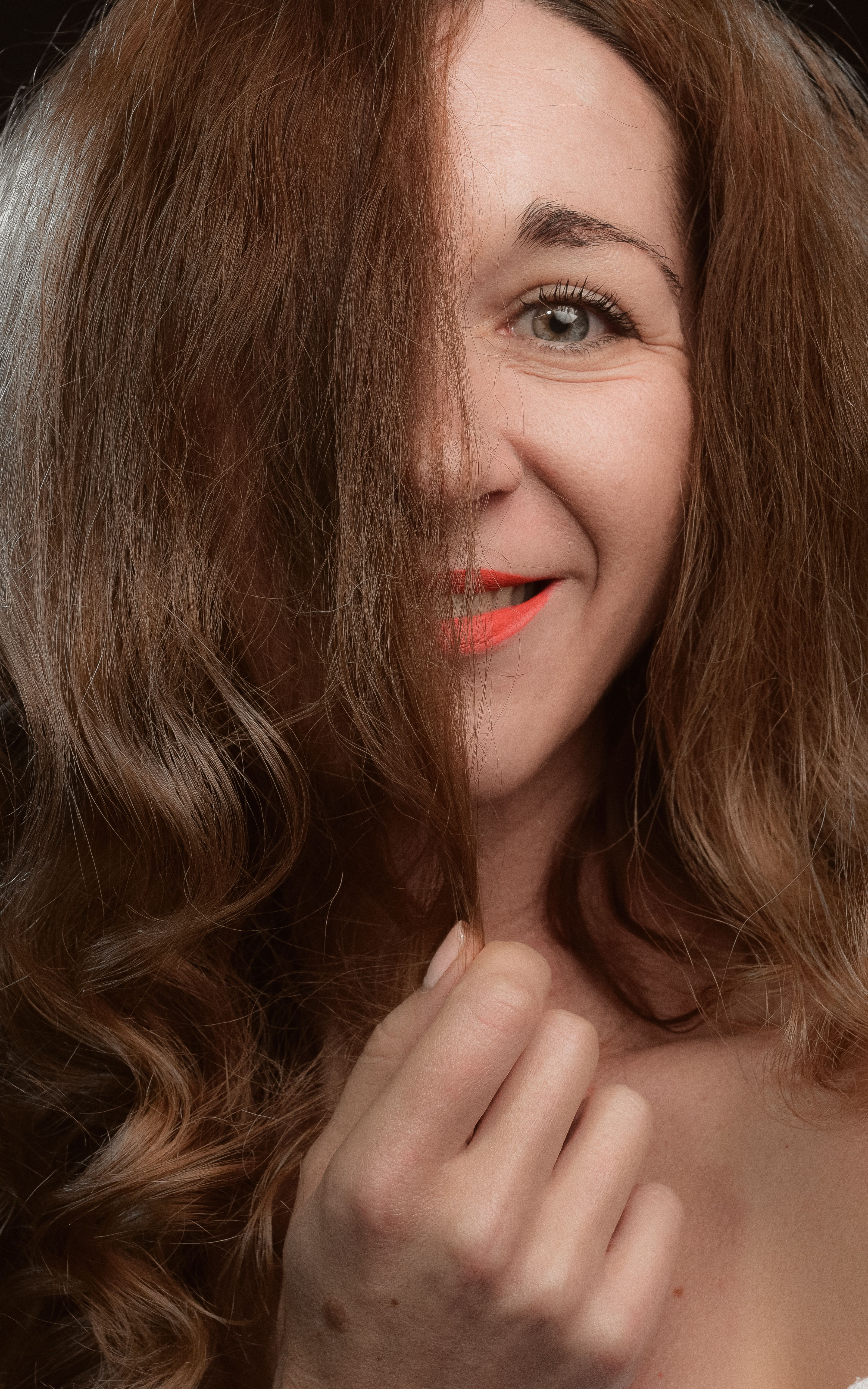 Close-up portrait of a smiling woman with brunette hair and bright lipstick in Kyiv.