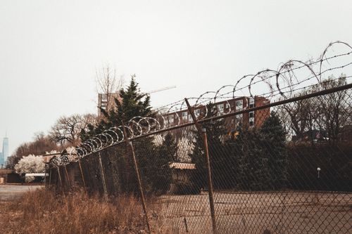Free A rusty barbed wire fence with cityscape in the background, showcasing urban security in Hoboken, NJ. Stock Photo