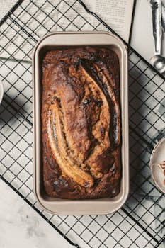 Top view of a delicious homemade banana bread fresh from the oven placed on a cooling rack. Enjoy the warm and inviting aroma.