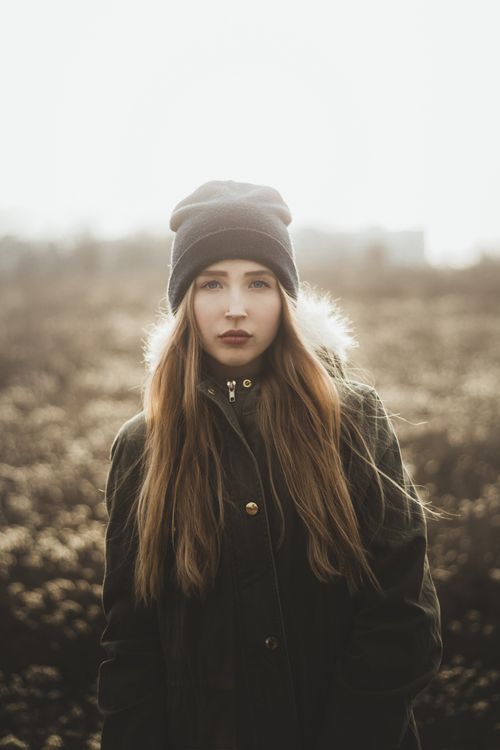 Free Young stylish female with long straight hair looking at camera while walking in autumn park Stock Photo