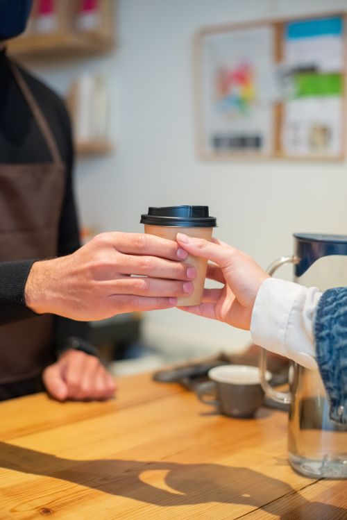 Free Close-up of a barista serving a coffee in a cozy Portuguese cafe. Warm and inviting ambiance. Stock Photo
