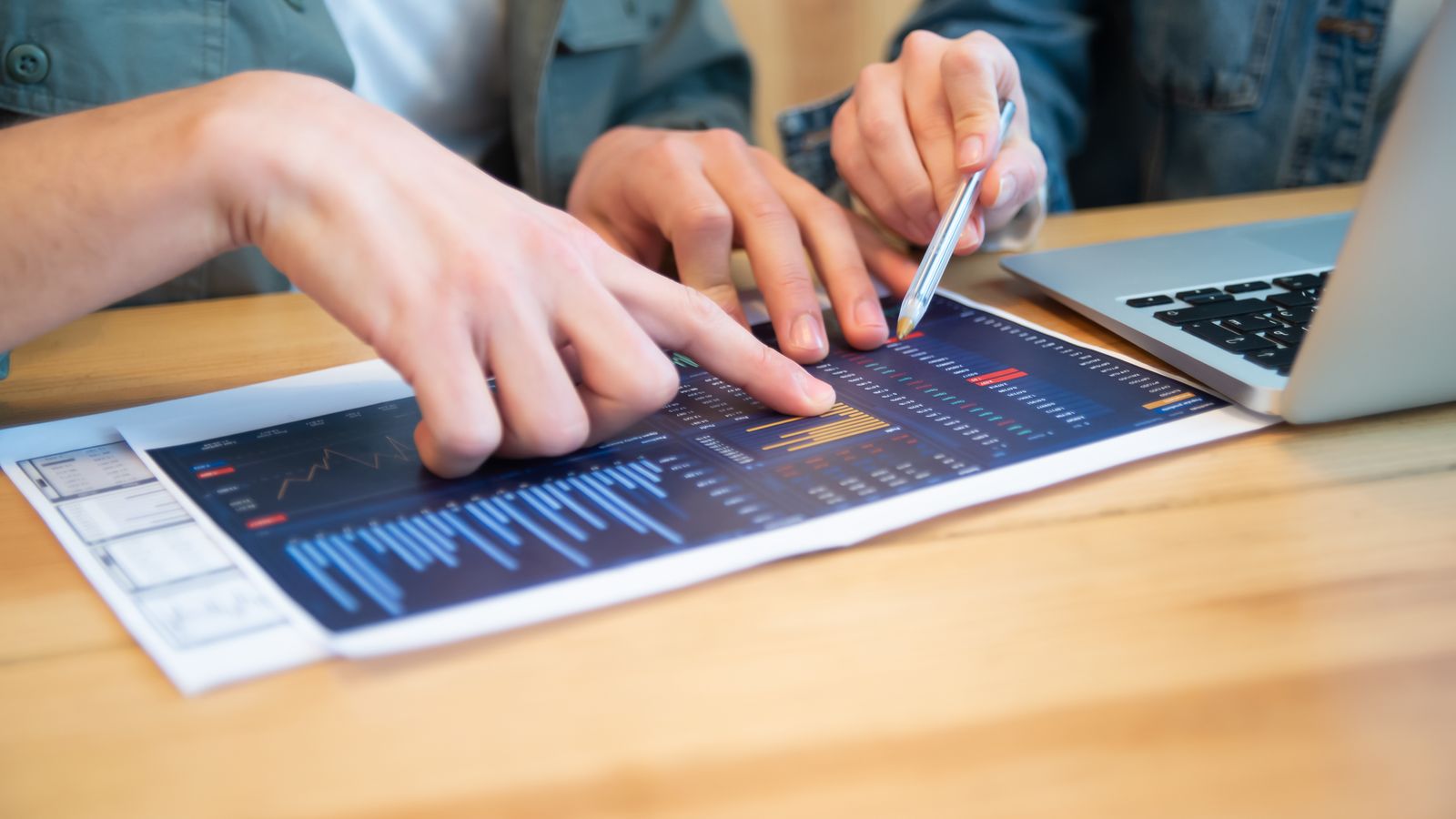 Business professionals comparing analytics reports and charts