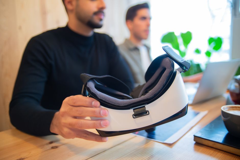 Professional team exploring virtual reality headset in an office setting for innovative solutions.