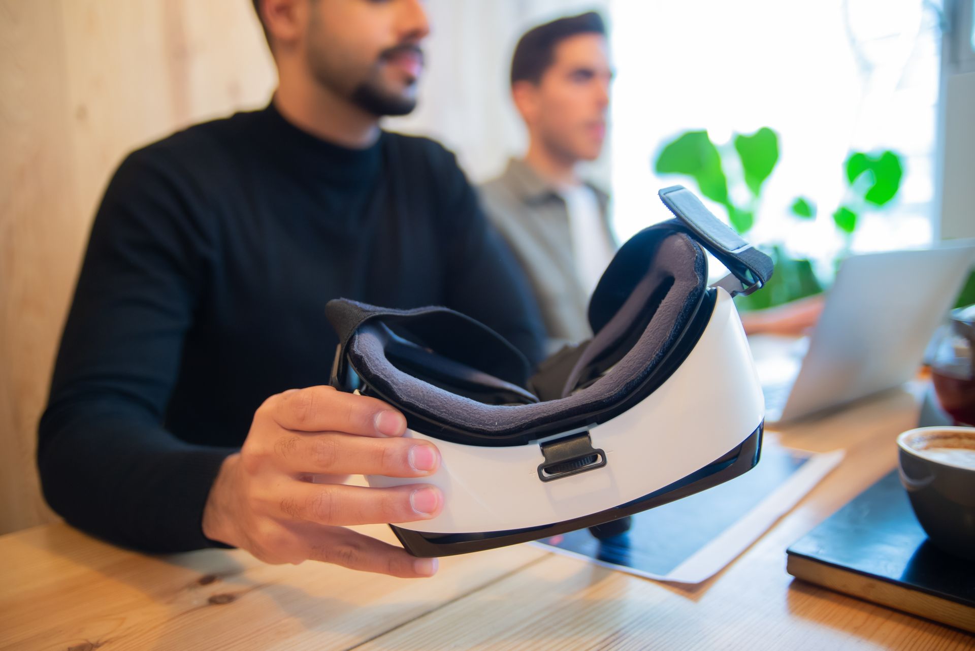Professional team exploring virtual reality headset in an office setting for innovative solutions.
