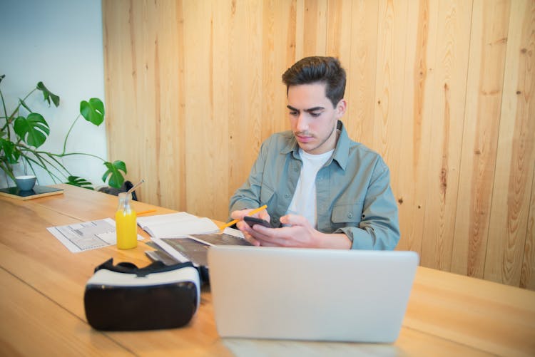 A Man Looking At His Cellphone While Working