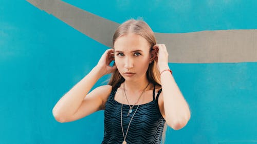 Woman touching hair near wall with pattern