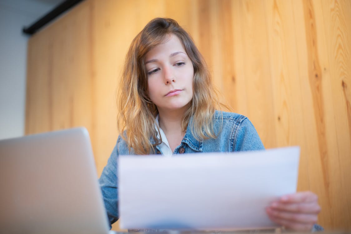 A Woman in Denim Jacket Looking at a Document