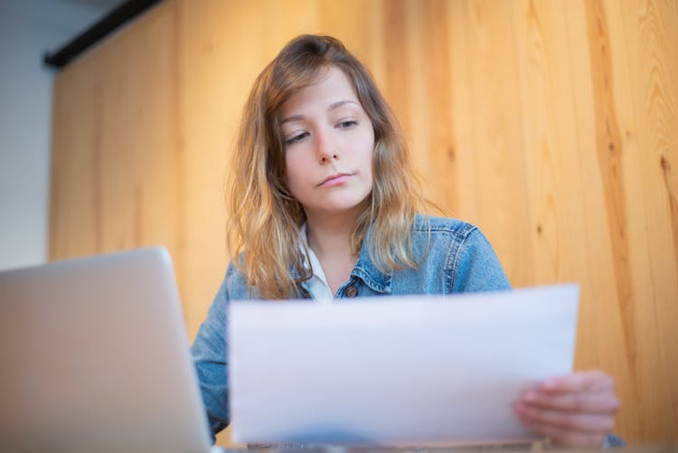 A Woman In Denim Jacket Looking At A Document