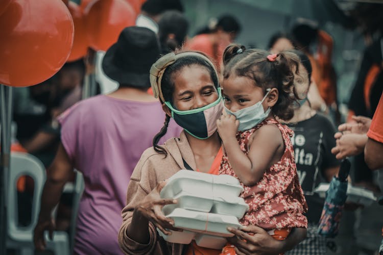 A Woman And A Child Wearing Facemasks