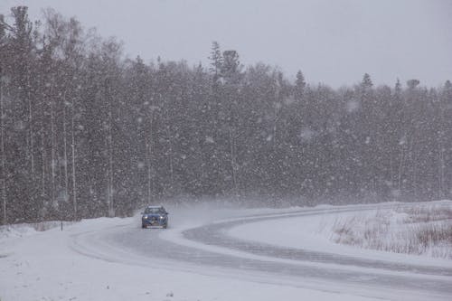 A Car on the Road During Snowfall
