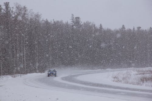 Free A Car on the Road During Snowfall Stock Photo