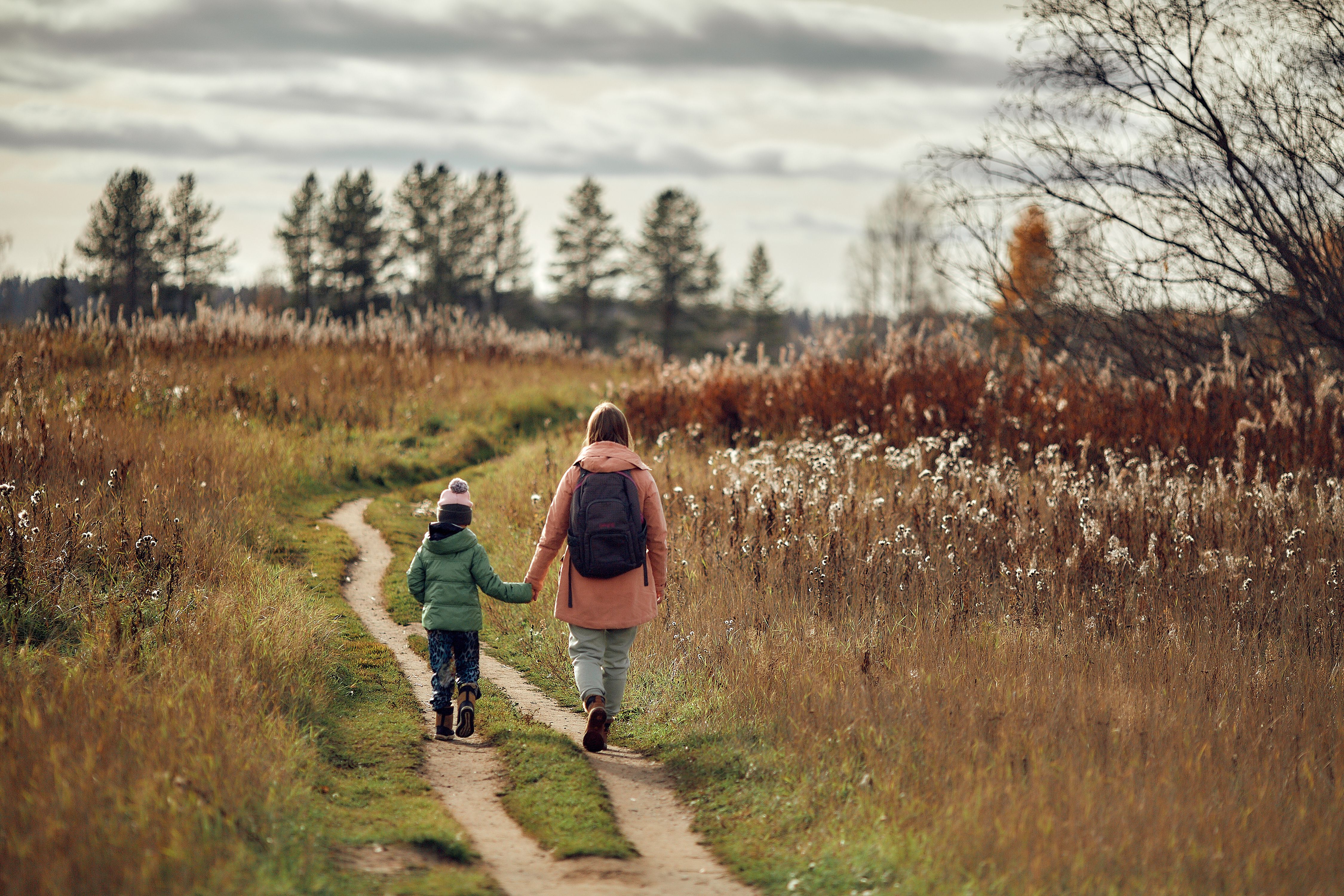Sister and little brother walking along dirt road · Free Stock Photo
