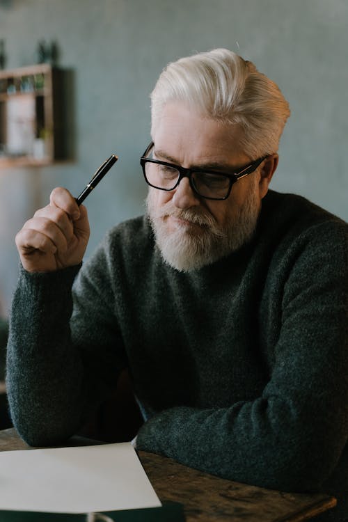 An Elderly Man Holding a Pen