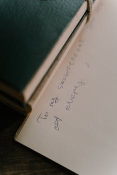 Artistic close-up of a handwritten note in a notebook with soft lighting.