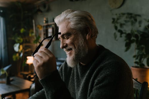 Free A Bearded Man with Gray Hair Holding an Eyeglasses Stock Photo