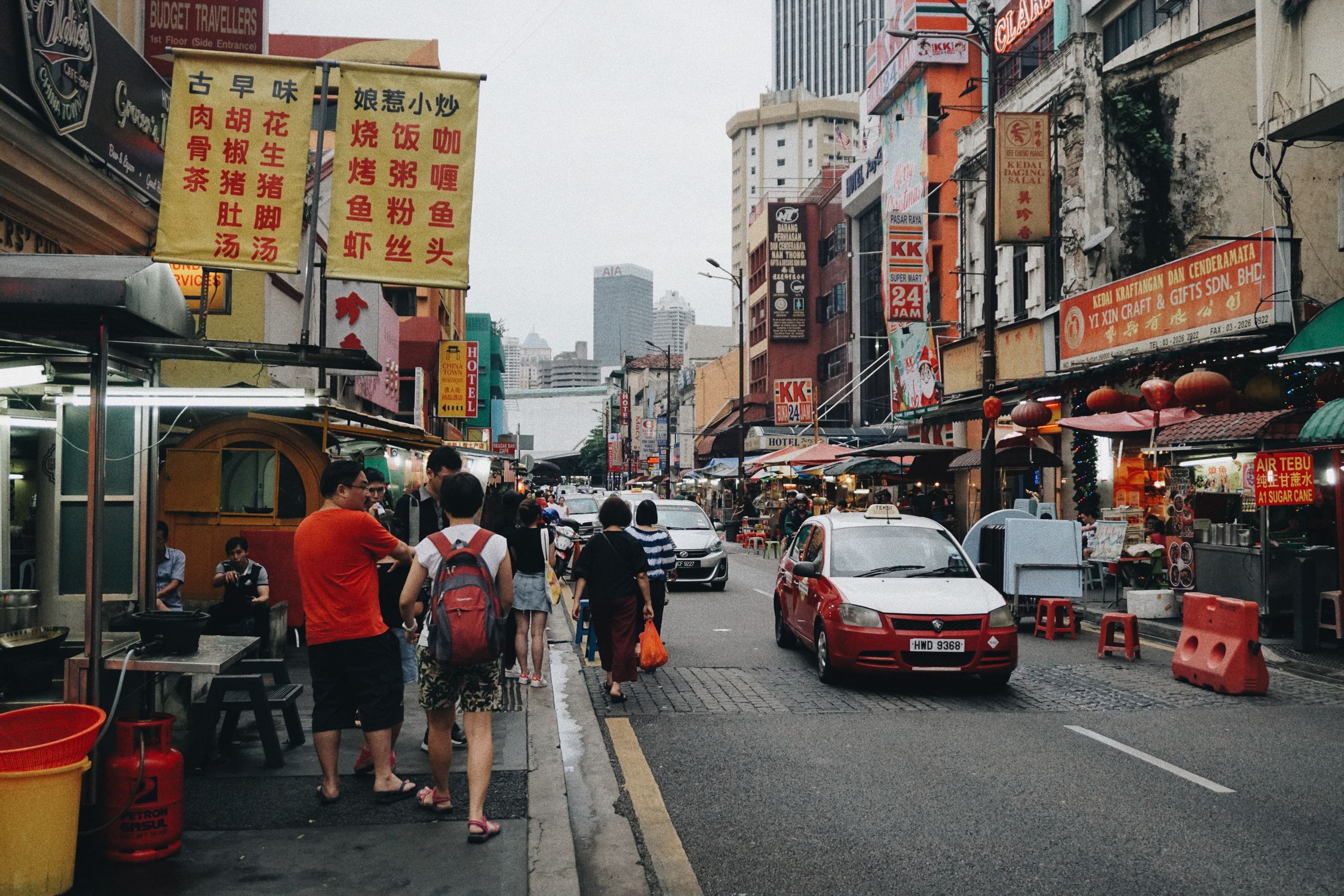 Vibrant street scene in Kuala Lumpur's Chinatown showcasing bustling activity and colorful signage