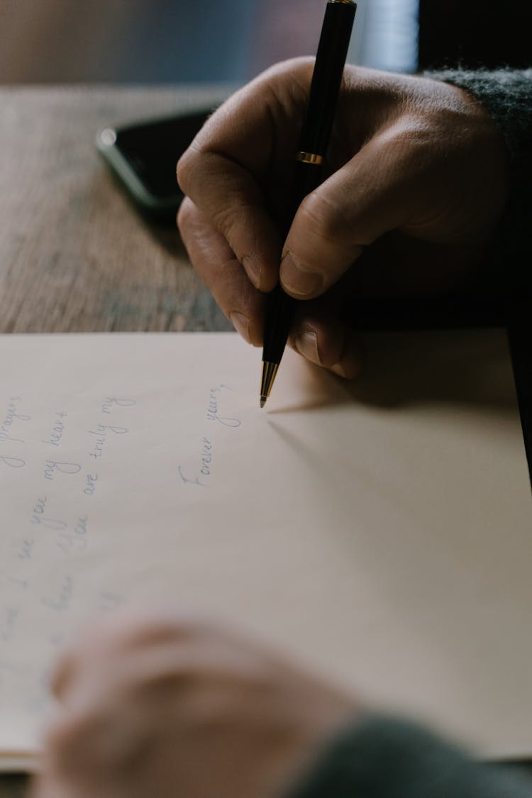 A Person Writing A Personal Letter