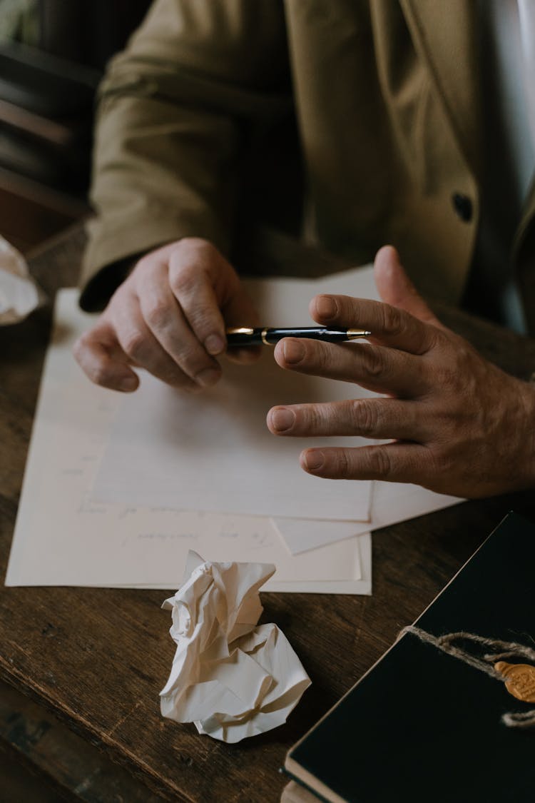 Crop Author With Pen And Paper Working At Table