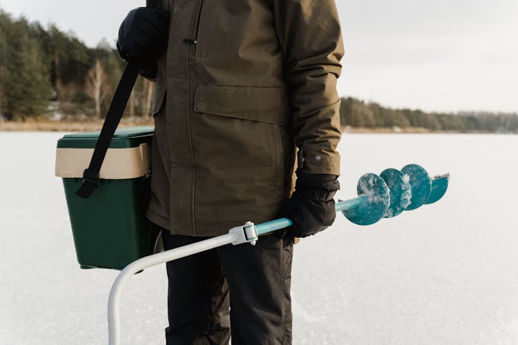 A Man Holding An Ice Auger