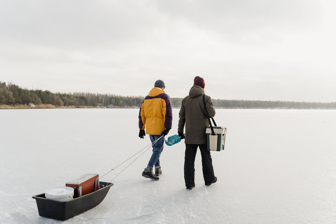 Men Walking on Frozen Lake with Exploration Tools