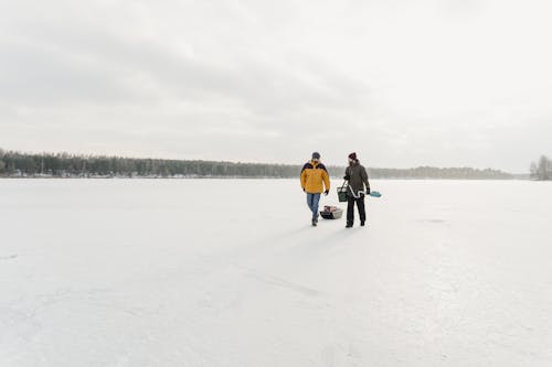 Men Walking in Frozen Lake for Exploration