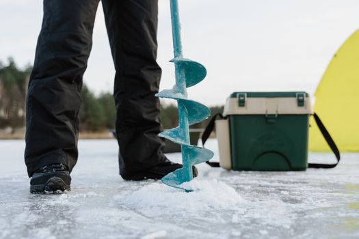 Person Drilling a Frozen Lake
