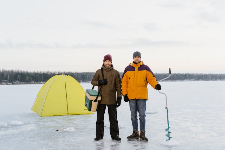 Photo Of Men Standing On Frozen Lake