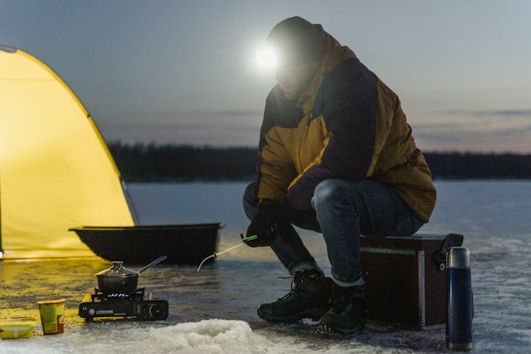 Photo Of A Man Fishing In A Frozen Lake