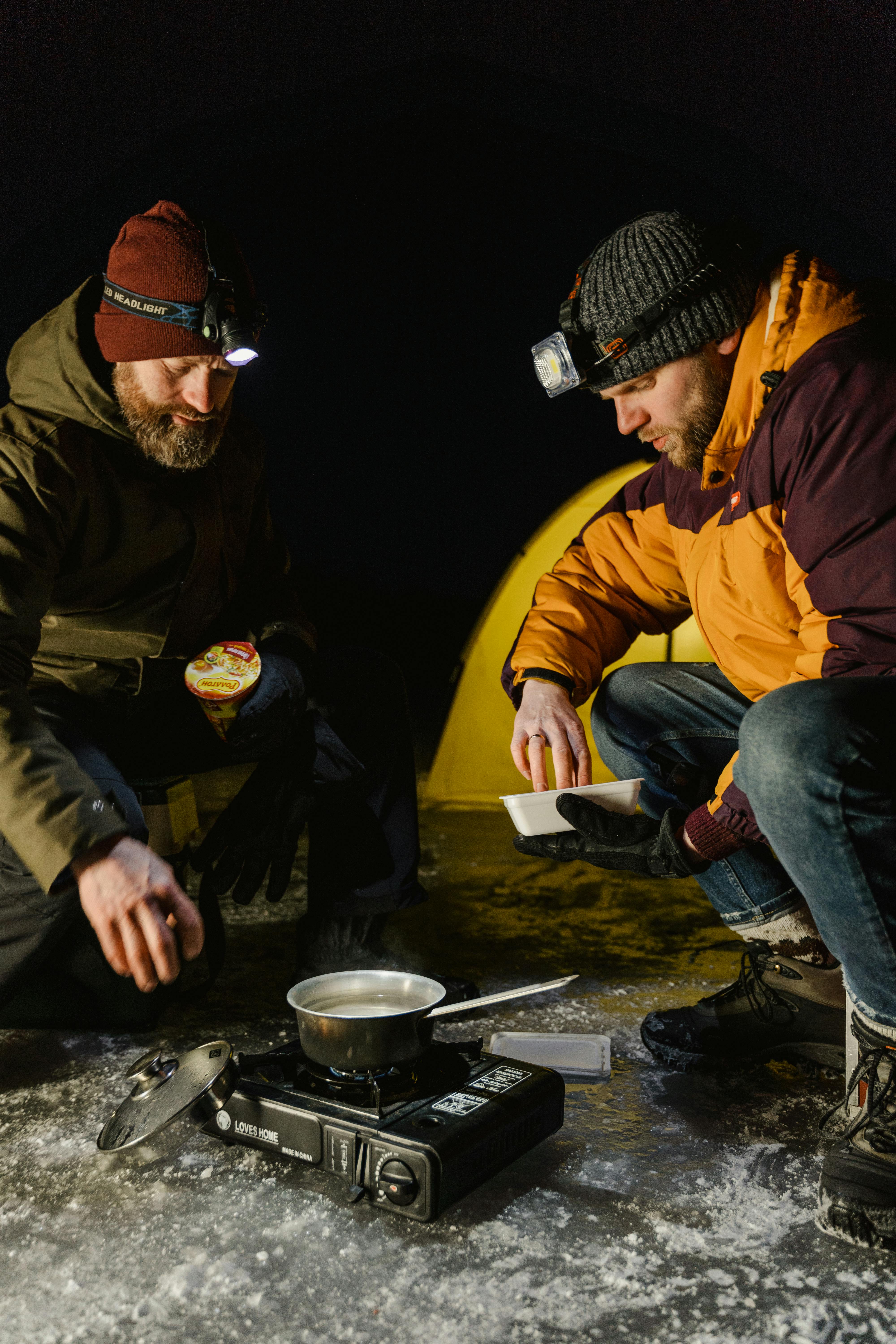 men cooking on frozen lake