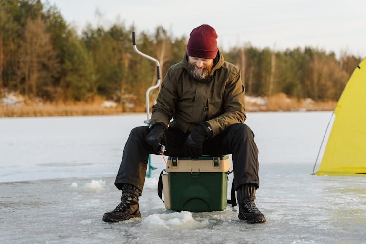 A Man Fishing On Frozen Lake