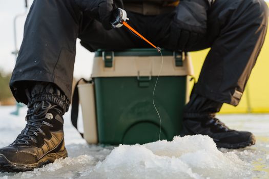 Person ice fishing on a frozen lake in winter, showcasing outdoor activity and gear.