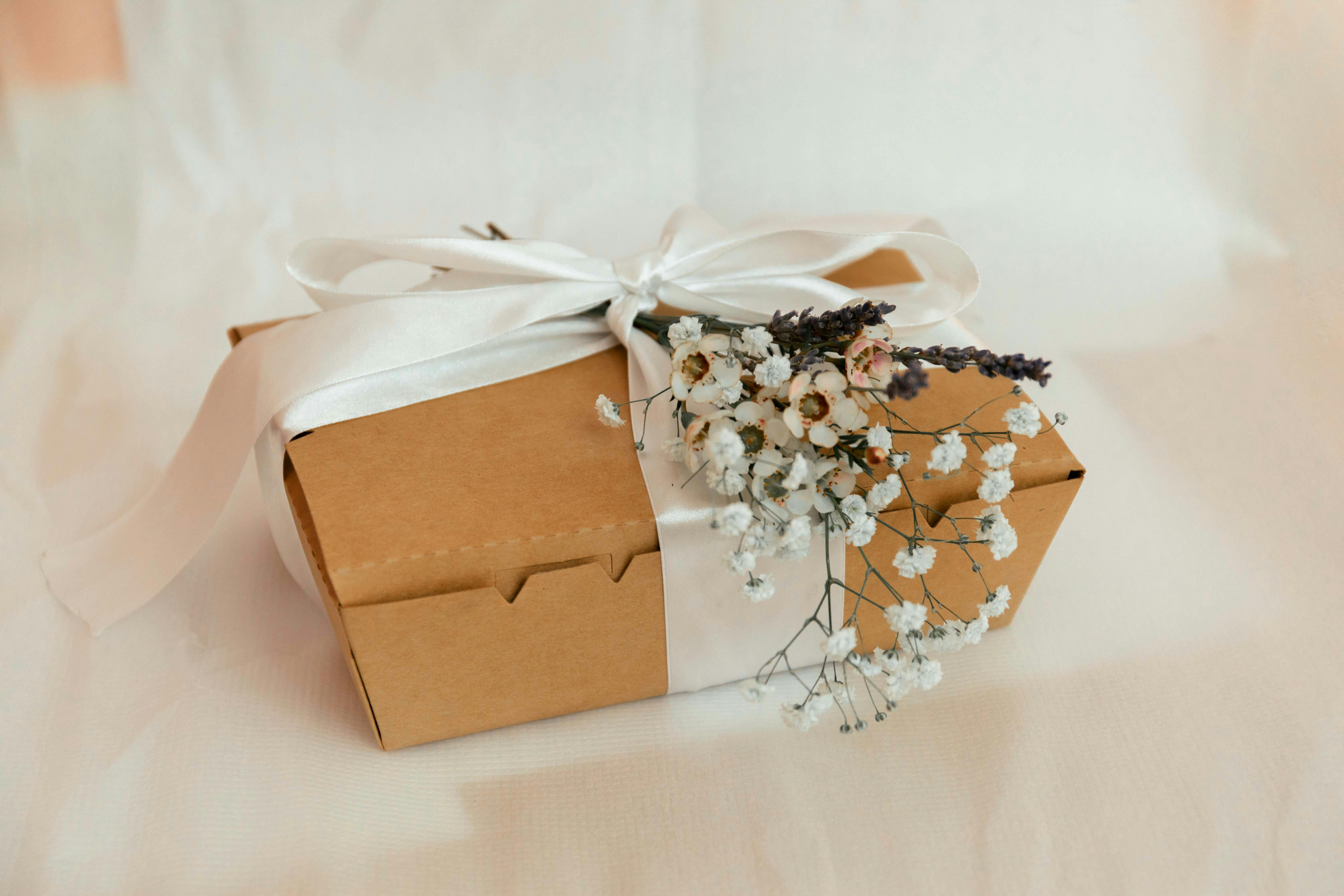 carton box tied with ribbon and flowers