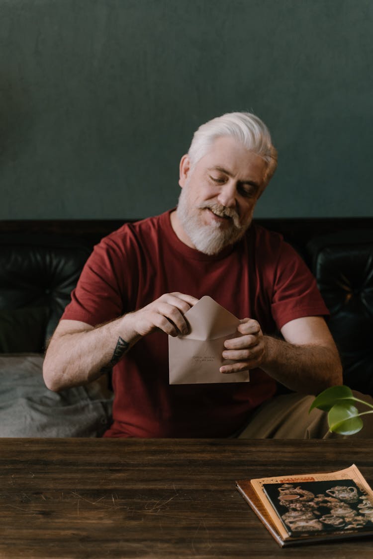 An Elderly Man Holding A Brown Envelope