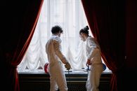 Man in White Dress Shirt and White Pants Standing Beside Woman in White Dress