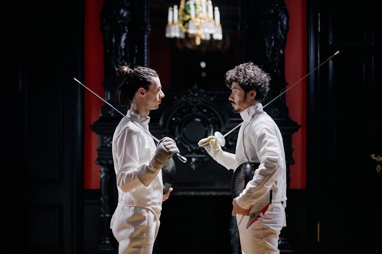 Men Fencers Looking At Each Other While Holding Their Fencing Foils