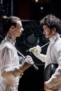 Two Men Facing Each Other Holding Fencing Gears