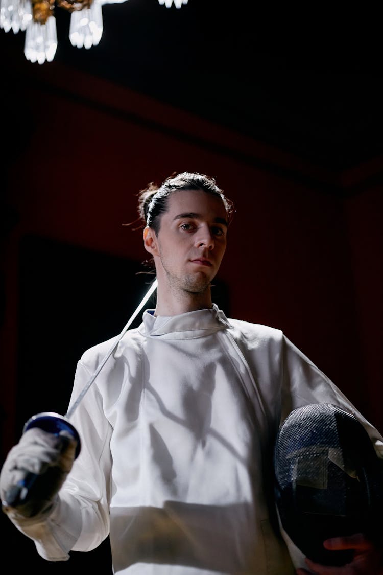 A Man Holding A Fencing Sword And Mask