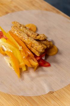 Close-up of fresh veggie roll ingredients with tempeh, showcasing colorful and healthy food prep.